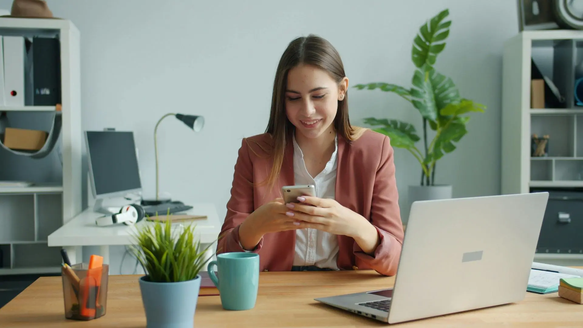 Young business owner texting an accounting firm while using a modern CRM and website chat system in a contemporary workspace.